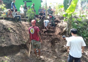 Bersama TNI, Warga RW 7 Pisang Candi Lakukan Pemasangan Paving Jalan