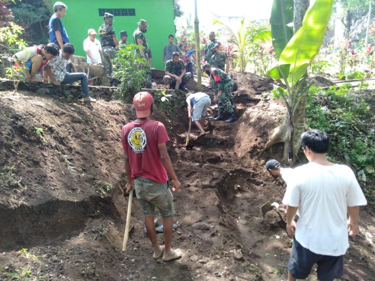 Bersama TNI, Warga RW 7 Pisang Candi Lakukan Pemasangan Paving Jalan